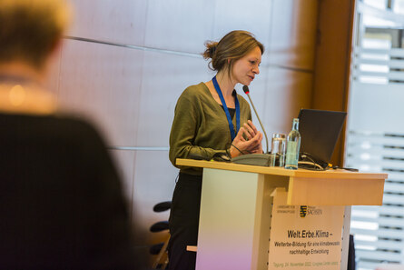 Frau spricht auf einem Podium