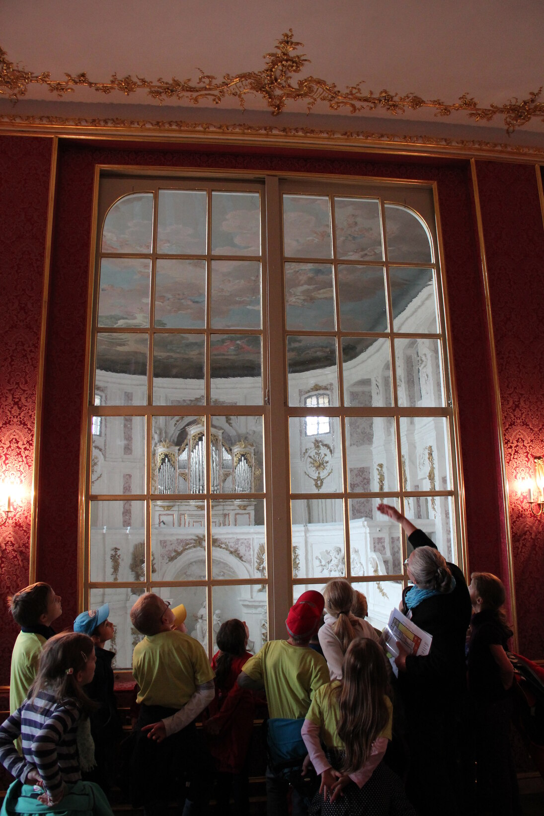 Schülergruppe mit einer Frau vor einer Glastür im Schloss Wermsdorf