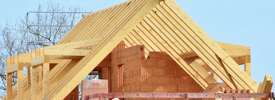 Zu sehen ist ein Dachstuhl im Bau aus Holz.