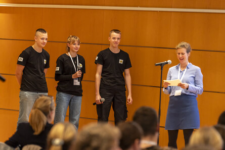 Gruppe von Personen stehen auf der Bühen und sprechen miteinander