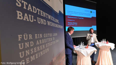 Zu sehen ist ein Banner mit dem Schriftzug "Stadtentwicklung, Bau und Wohnungswesen, für ein gutes Leben und Arbeiten in unseren Städten und Gemeinden