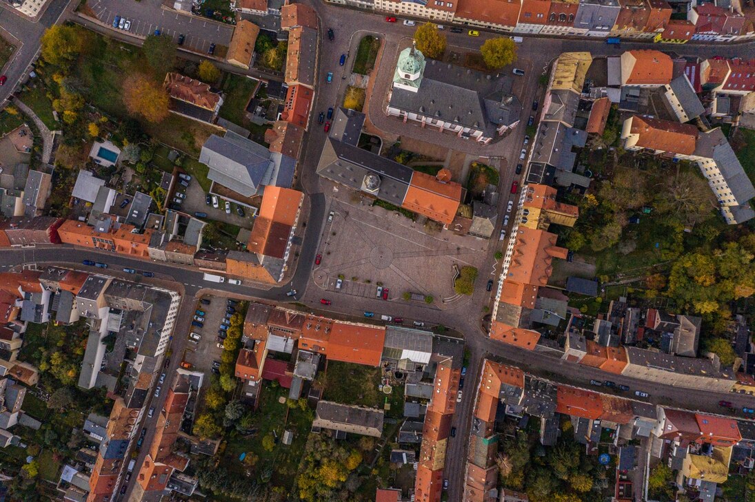 Das Bild zeigt Roßwein von oben, aber ganz vertikal also Blick durch die Wolken. Man sieht Häuser, Straßen und einen Platz